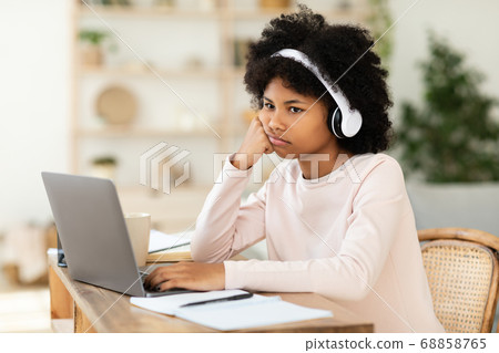 Bored African American Teen Girl Sitting At Laptop At Home 68858765