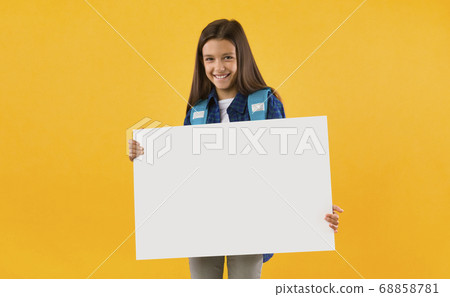 Excited girl holding white paper for promo Excited girl holding white paper for promo 68858781