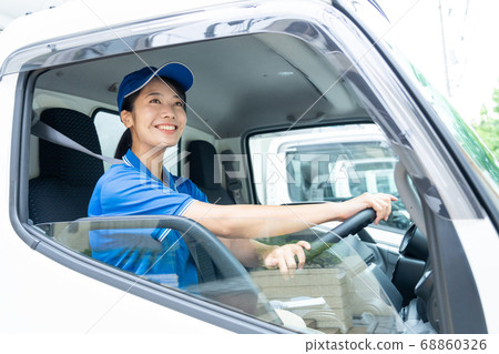 Young female driver driving a truck 68860326