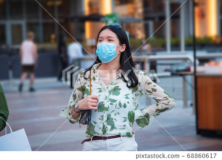 Asian woman wearing face mask in outdoors shopping Asian woman wearing face mask in outdoors shopping 68860617