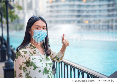 Happy female Asian tourist wearing face mask at Happy female Asian tourist wearing face mask at 68860619
