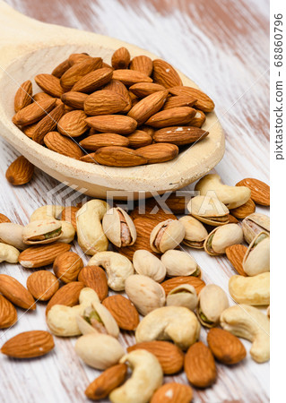 Almonds in a wooden spoon on a wooden background. 68860796