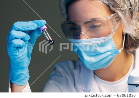 Female scientist looking at test tube with blood sample in laboratory 68861856