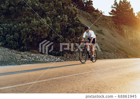 Professional cyclist on a mountain road at sunrise 68861945