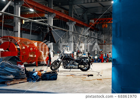 Motorcycle standing in a dark hangar building 68861970