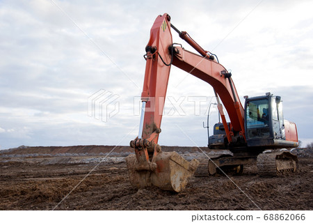 Red excavator during earthworks at construction site Red excavator during earthworks at construction site 68862066