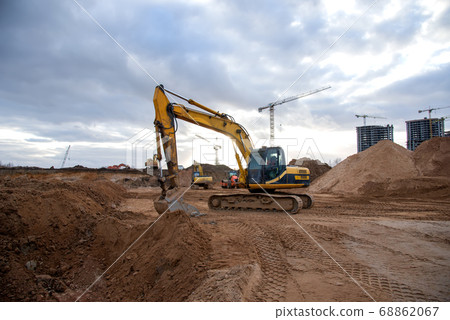 Excavator during earthmoving at construction site. Excavator during earthmoving at construction site. 68862067