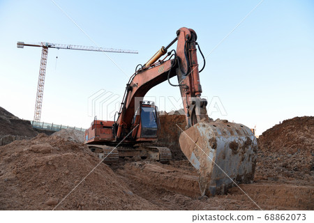 Excavator during earthmoving at construction site. Excavator during earthmoving at construction site. 68862073