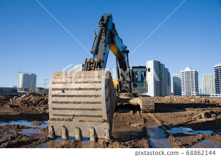 Excavator during earthmoving at construction site Excavator during earthmoving at construction site 68862144