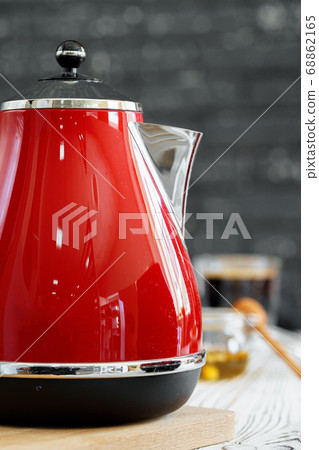 Red kettle on kitchen table close up Red kettle on kitchen table close up 68862165
