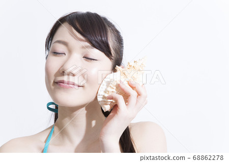 A woman in a swimsuit with a shell 68862278