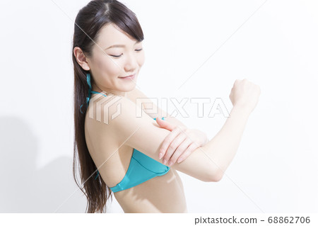 泳裝的一名婦女佩帶的遮光劑 68862706