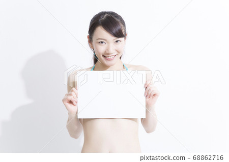 A woman in a swimsuit with a message board 68862716
