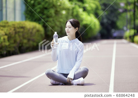 Young woman holding a plastic bottle in sportswear Young woman holding a plastic bottle in sportswear 68864248