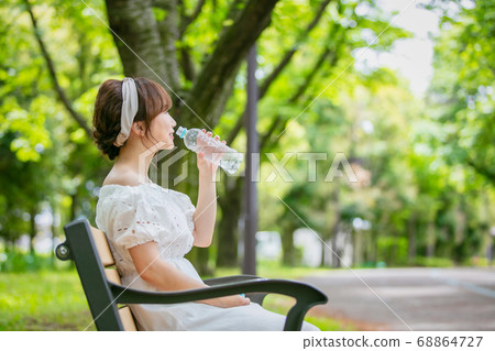 Asian woman drinking water from a plastic bottle 68864727