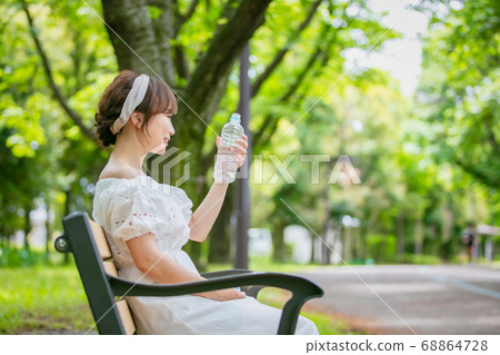 Asian woman drinking water from a plastic bottle 68864728