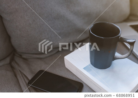 Cup of coffee with mobile phone on sofa in living 68868951