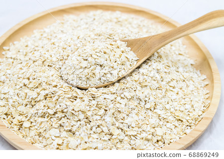 Oat flakes in bowl and wooden spoon 68869249