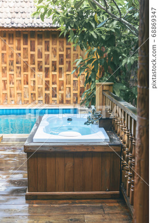 Bathtub filled with clean water on terrace of 68869347