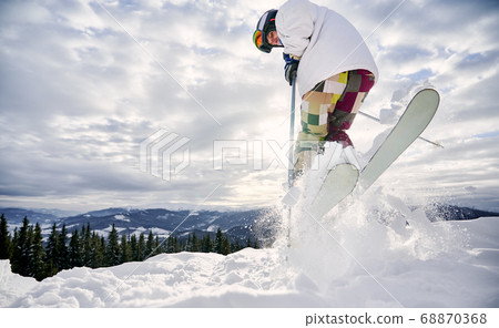 Winter kinds of sport. Skier doing tricks in the mountains in winter season Winter kinds of sport. Skier doing tricks in the mountains in winter season 68870368
