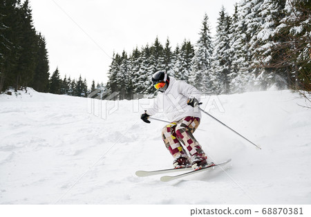 Winter kinds of sport. Skier doing tricks in the mountains in winter season Winter kinds of sport. Skier doing tricks in the mountains in winter season 68870381