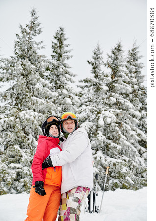 Happy young couple hugging in winter mountain forest. Happy young couple hugging in winter mountain forest. 68870383