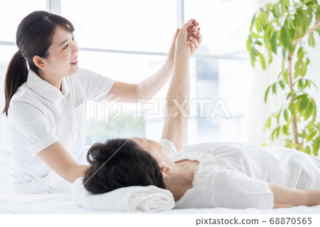 Medical senior woman doing gymnastics with physical therapist 68870565