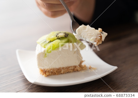 Woman eating rare cheesecake 68873334