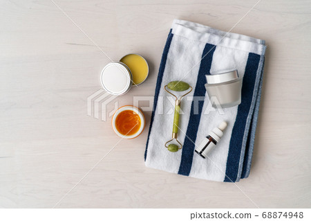 Natural skincare products - organic diy mud mask facial treatment Luxury spa bathroom women beauty creams and balm with jade face roller on towel. Top view background 68874948