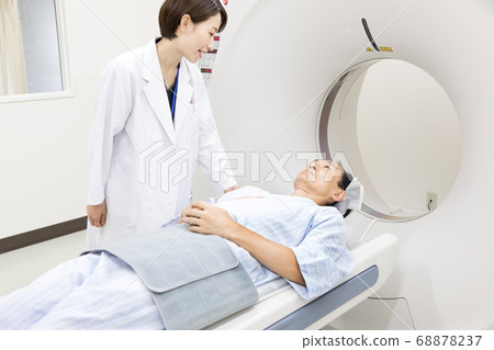 Middle-aged man undergoing CT examination 68878237
