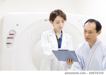 Middle-aged man undergoing CT examination 68878339