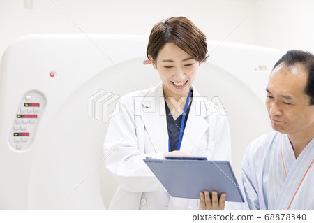 Middle-aged man undergoing CT examination 68878340