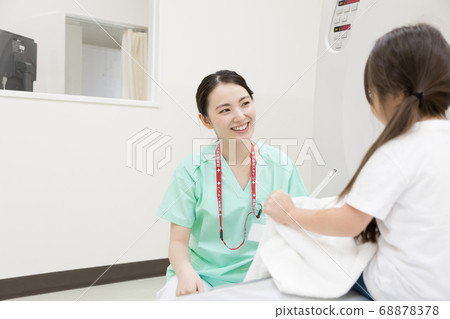 Girl undergoing CT examination 68878378