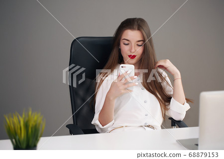 Business woman sitting at a desk with a laptop and looking away in the office 68879153