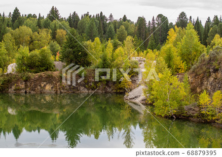 Stunning photo of fall foliage reflected on a lake with a glass like mirror water surface 68879395