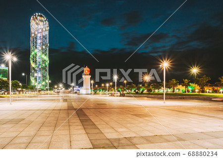 Batumi, Adjara, Georgia. Illuminated Alphabet Tower And Lighthouse At Promenade Near Miracle Park, Amusement City Park On Evening Or Night Sky Background. Blue Hour. Modern Urban Architecture 68880234