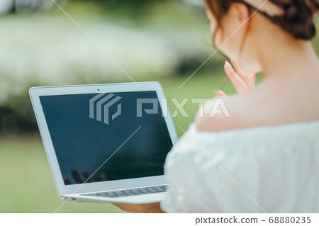 Woman using a laptop Woman using a laptop 68880235