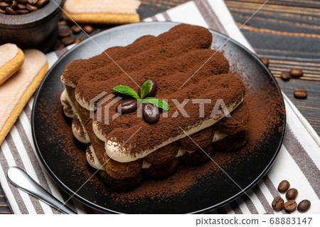 Classic tiramisu dessert on ceramic plate on wooden background Classic tiramisu dessert on ceramic plate on wooden background 68883147