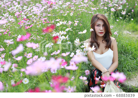 cute and beautiful girl standing in nature outdoors among cosmos flowers field with hat cute and beautiful girl standing in nature outdoors among cosmos flowers field with hat 68883839