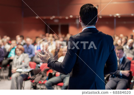 Public speaker giving talk at business event. 68884020
