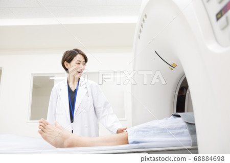 Middle-aged man undergoing CT examination 68884698