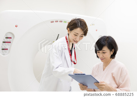 Middle-aged woman undergoing CT examination 68885225
