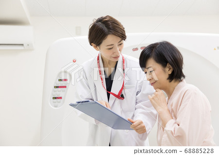 Middle-aged woman undergoing CT examination 68885228