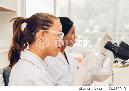 Side View Of Female Scientist With Colleague Side View Of Female Scientist With Colleague 68886043