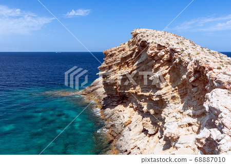 Cape Punta Galera. Ibiza, Balearic Islands, Spain. A wave frozen in stone in the emerald sea. Cape Punta Galera. Ibiza, Balearic Islands, Spain. A wave frozen in stone in the emerald sea. 68887010