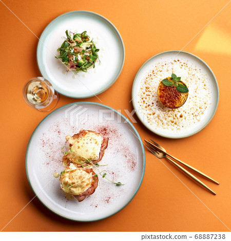 Benedict eggs - poached eggs and a delicious avocado salad, dessert cr me brulee in orange background 68887238