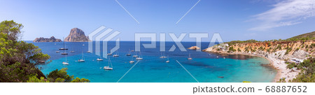 Beautiful panorama of the beach Cala Hort and the mountain Es Vedra with sea sailing yachts. Beautiful panorama of the beach Cala Hort and the mountain Es Vedra with sea sailing yachts. 68887652