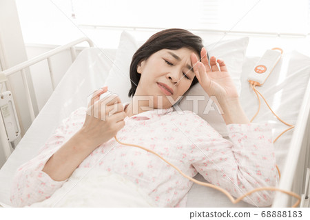 Middle-aged woman using nurse call 68888183