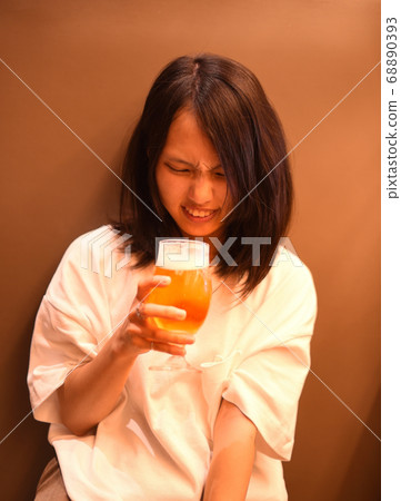 Young woman who is reluctant to drink beer 1 Young woman who is reluctant to drink beer 1 68890393
