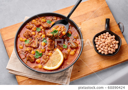 Moroccan Harira Soup in black bowl at grey table top Moroccan Harira Soup in black bowl at grey table top 68890424